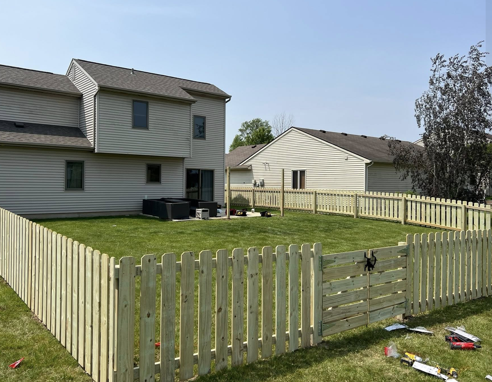 Custom wood privacy fence newly installed around a residential backyard by Strongscape